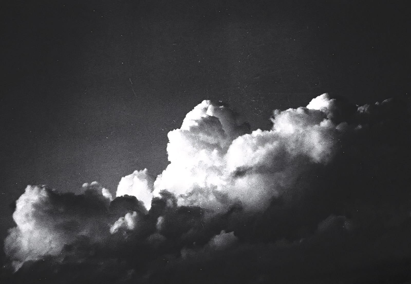 Dramatic clouds against dark sky, high contrast black and white.