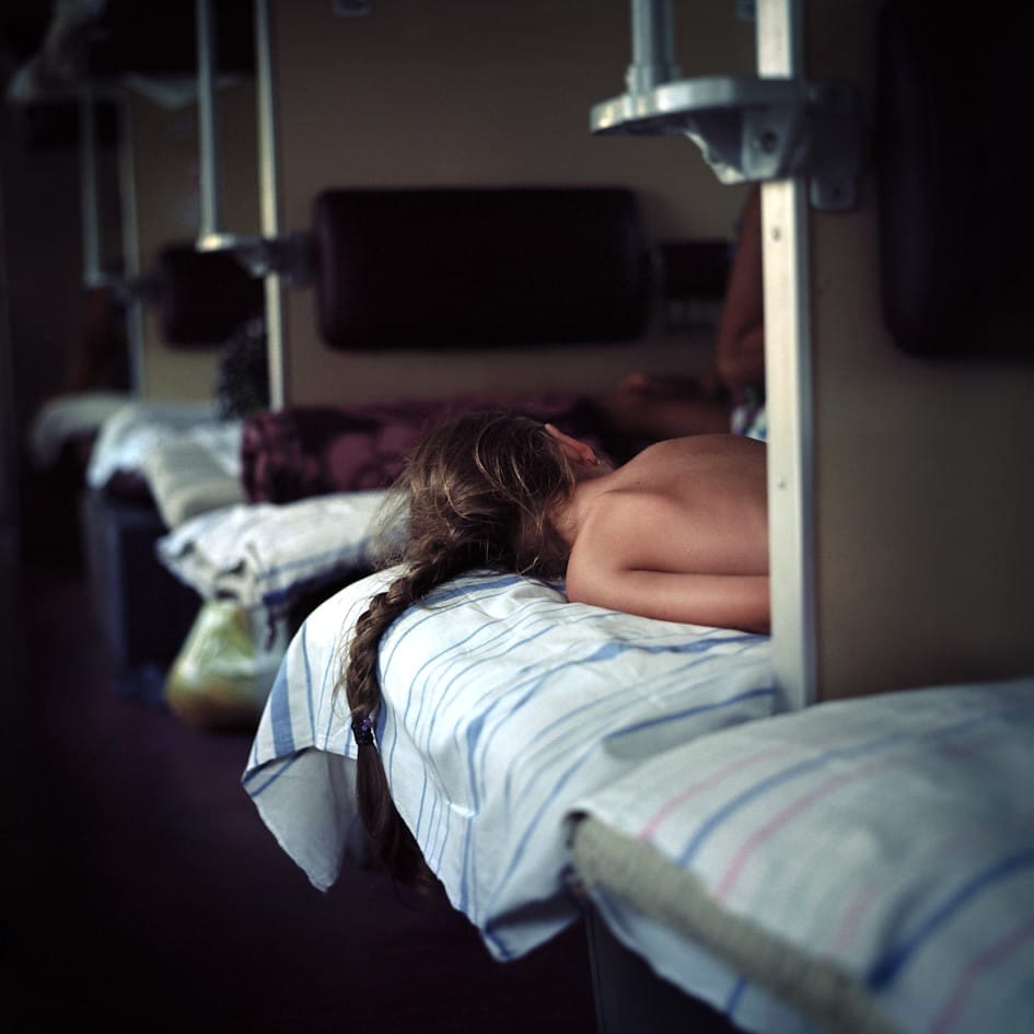 Girl resting comfortably on a sleeper train.