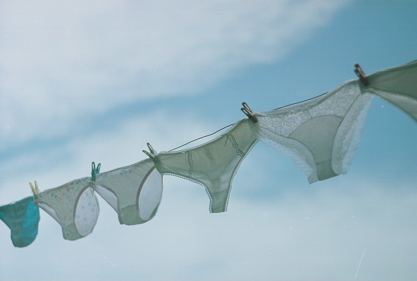 Delicate lace panties on a washing line outdoors.