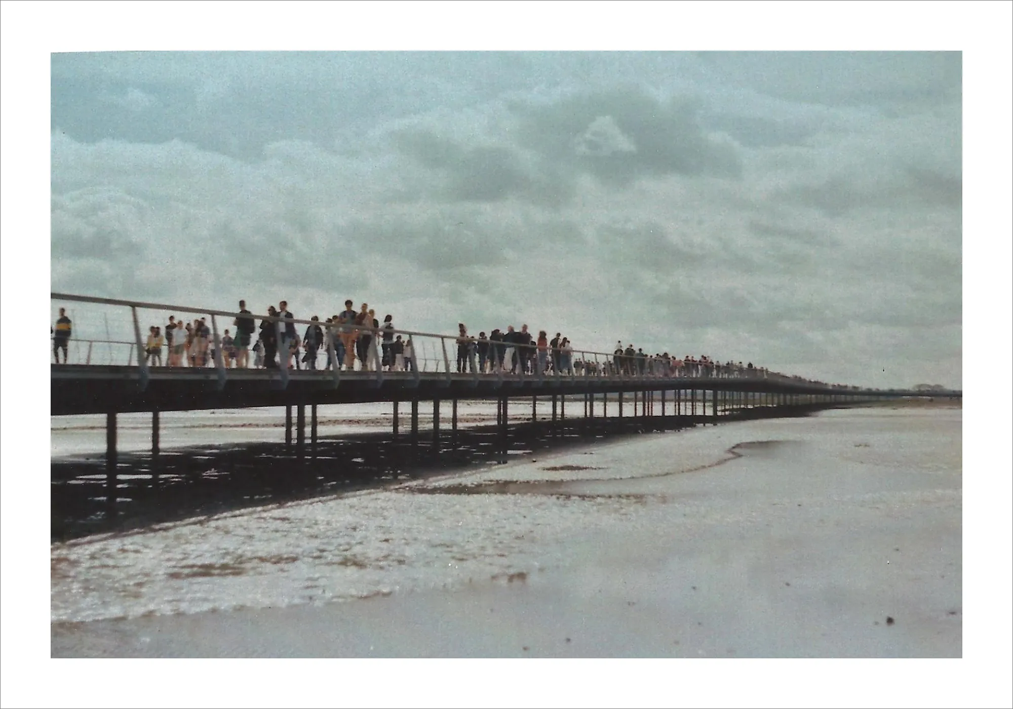 Long pedestrian bridge over tidal flats at Mont-Saint-Michel.
