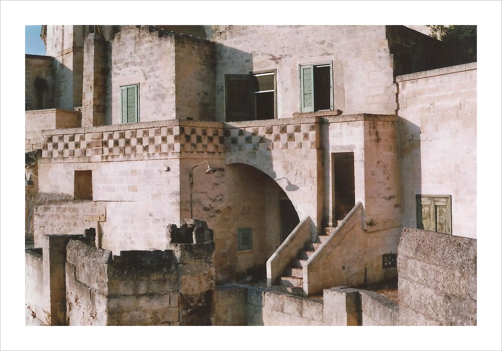 Weathered white stone buildings with shadows in Matera, Italy.