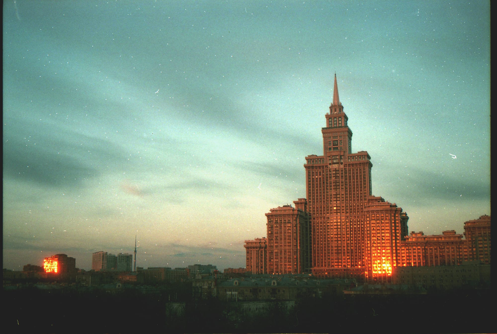 Soviet-era skyscraper at sunset with golden light on film.