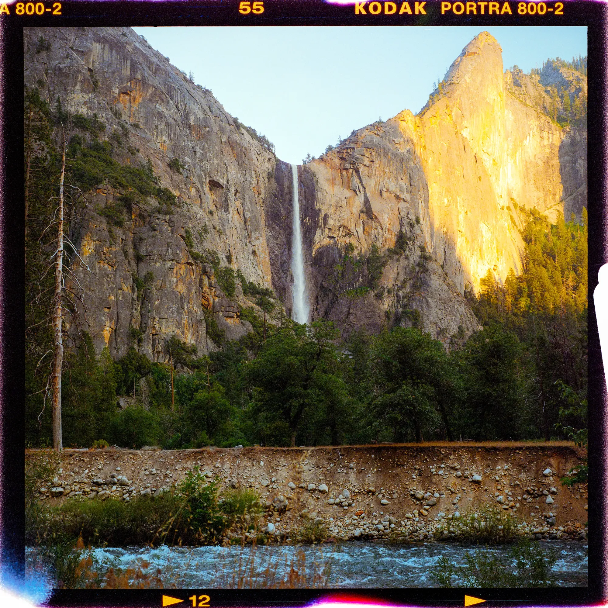 Yosemite waterfall at golden hour between granite cliffs on medium format film.