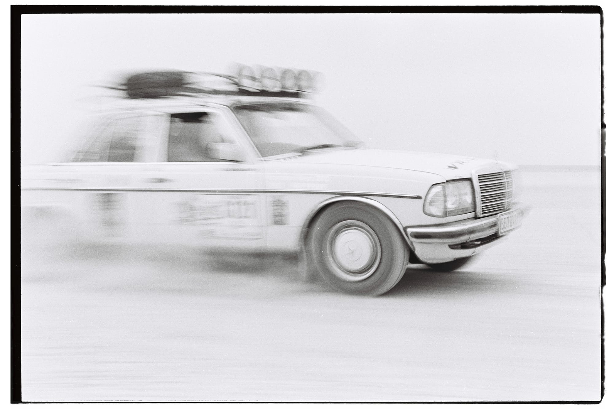 Mercedes sedan with heavy motion blur racing on pan.