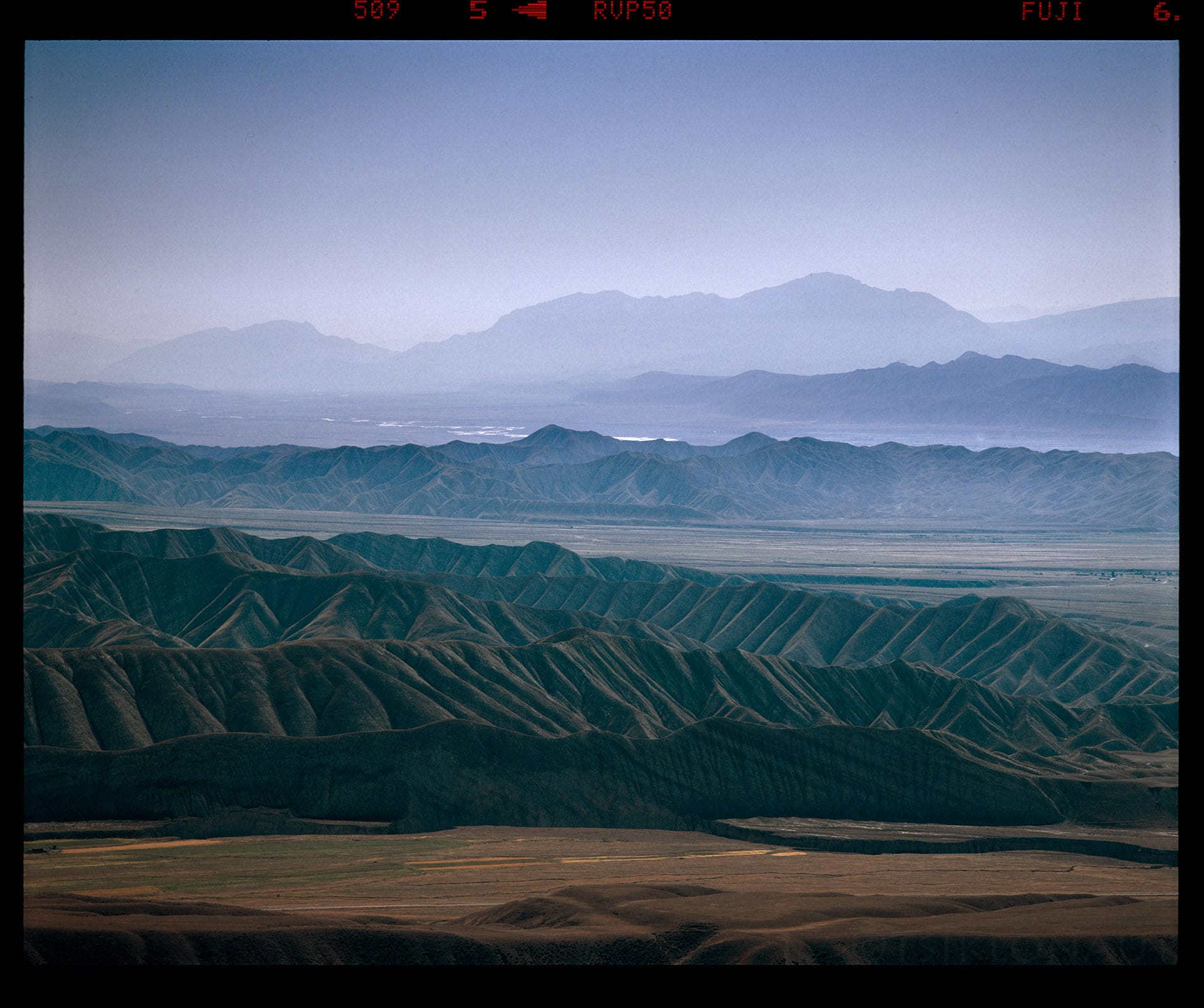 Layered mountain ridges recede into blue atmospheric haze.
