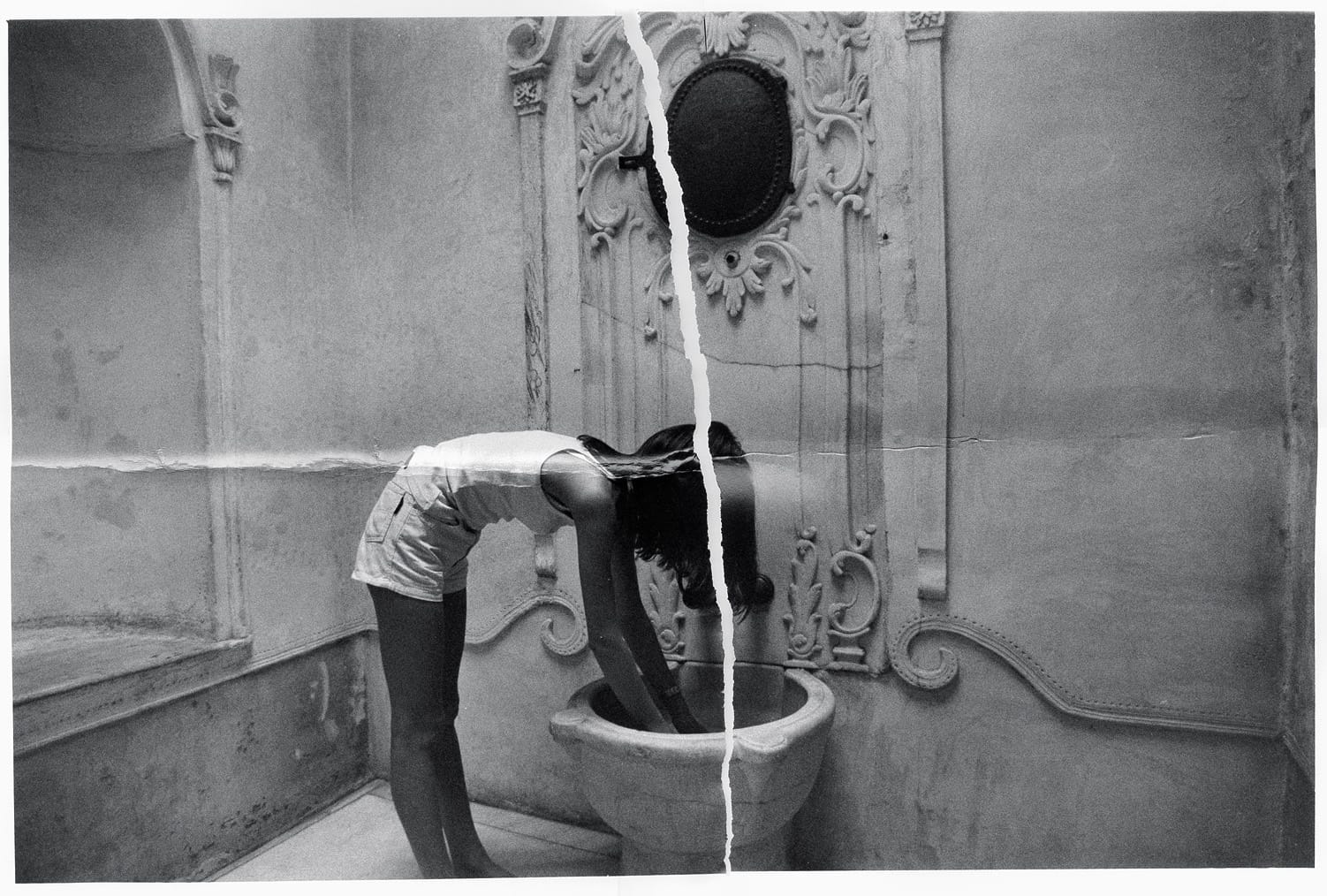 Black and white girl drinking from ornate fountain with vertical rip splitting image.